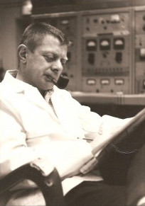 Sepia toned Hershel Hausman sitting and reading while smoking a pipe