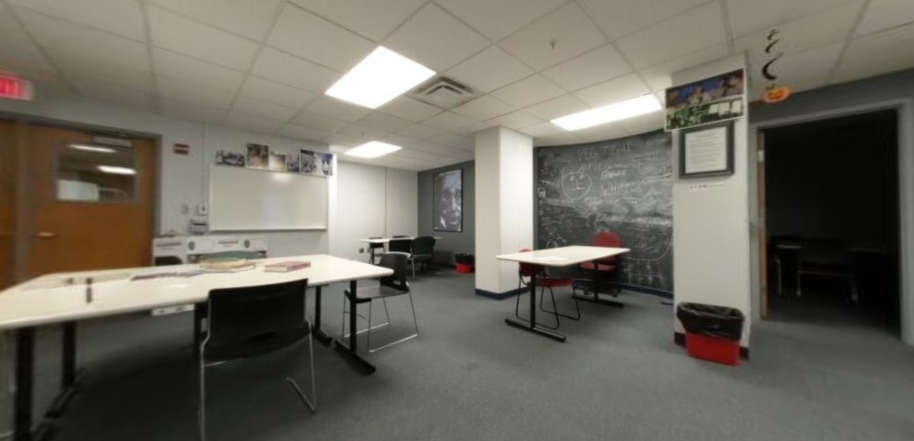"Before" photo of main area, dark study rooms behind doors, two small rectangular tables.