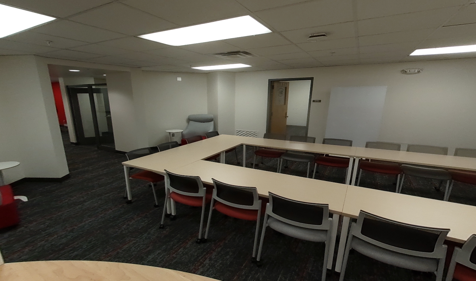 "After" photo of student lounge. Brighter, more open space, all new furniture and light wood table tops. More open-concept