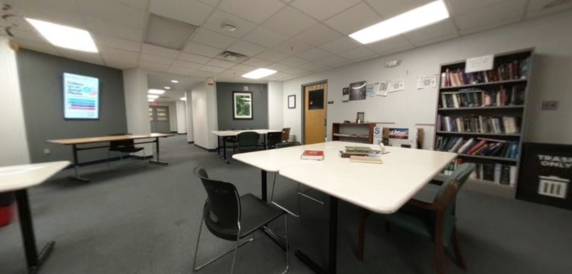 "Before" image of student lounge, dated furniture and lower light, crowded main space.