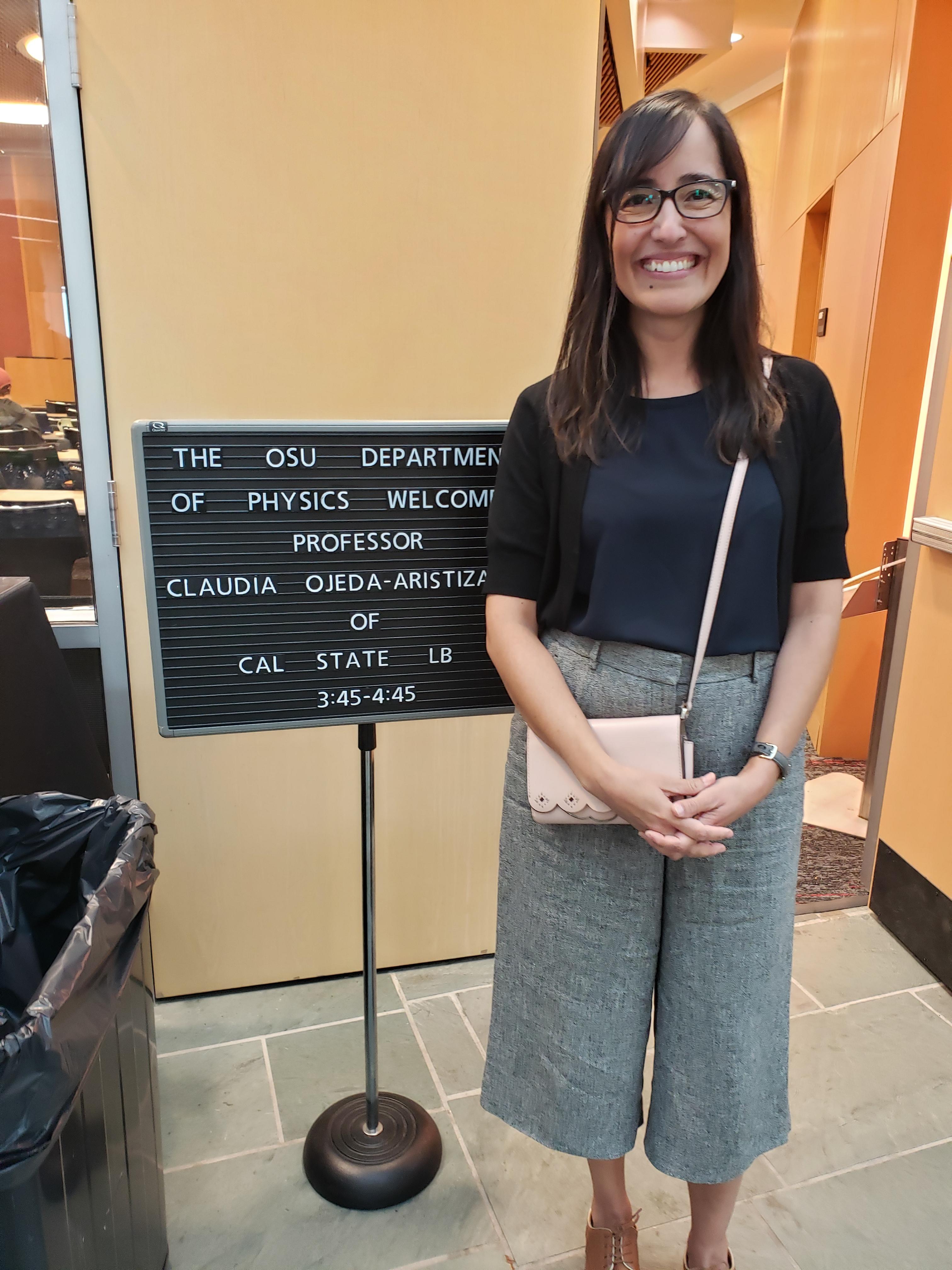 Photo of speaker Claudia Ojeda-Aristizabal with magnetic sign