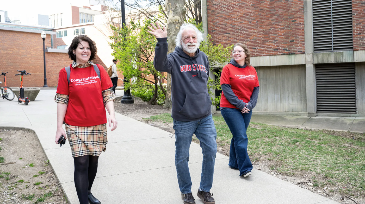 Agostini and two of his key university supports, Dawn Larzelere, left, and Jessi Middleton ’11, arrive at the clap-in to celebrate his Nobel