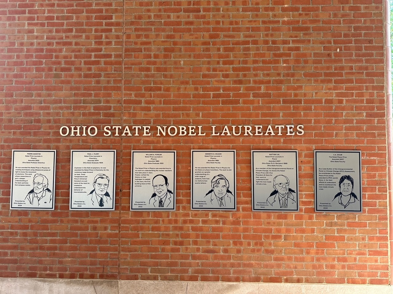 Row of silver Nobel Winner plaques on wall of 18th street library