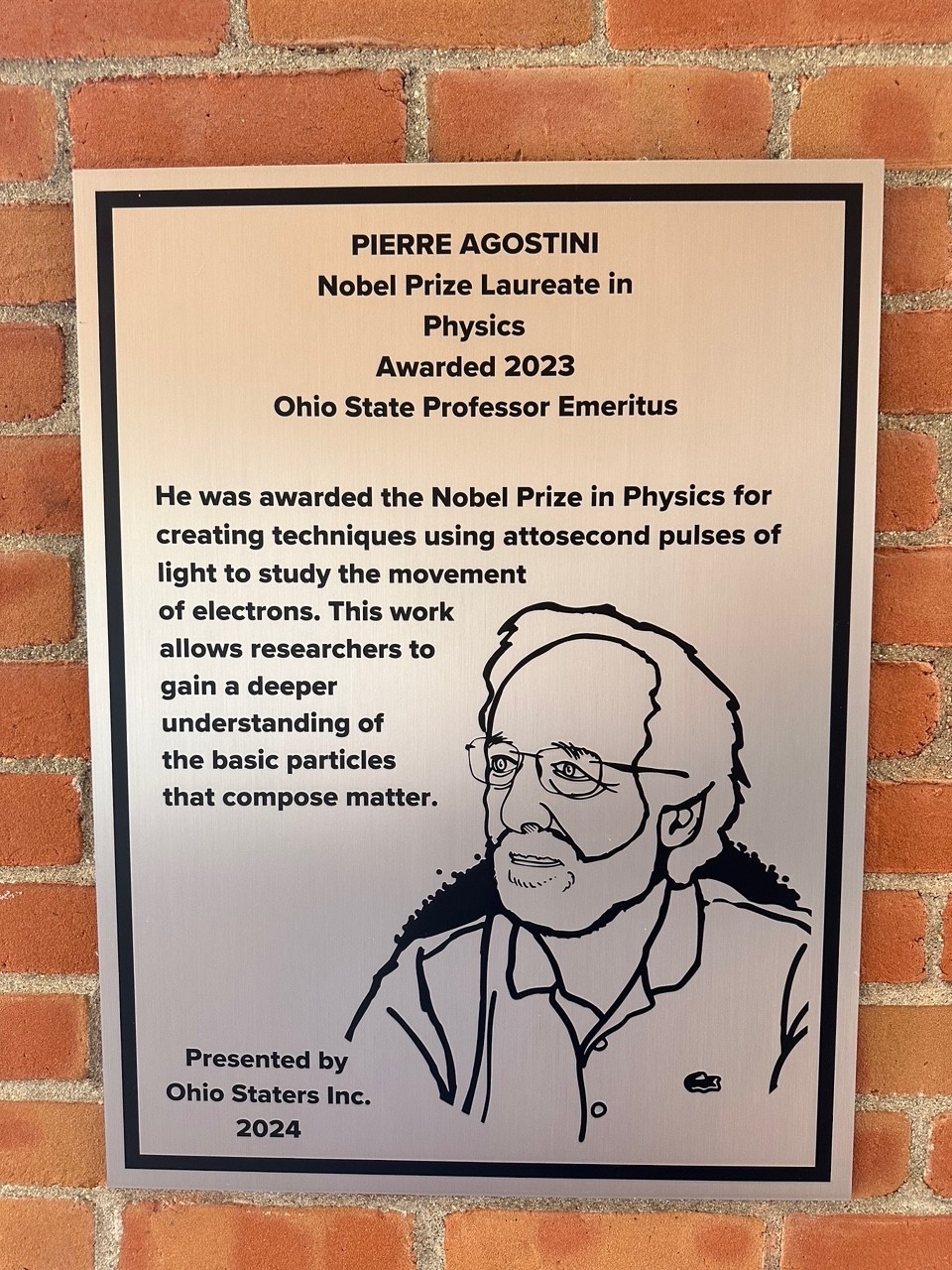 Pierre Agostini's silver plaque on the wall of the 18th street library