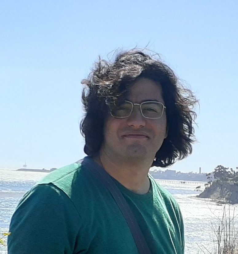 Alireza smiling with bright blue sky in the background