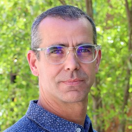 Eric Brewe in front of a line of trees