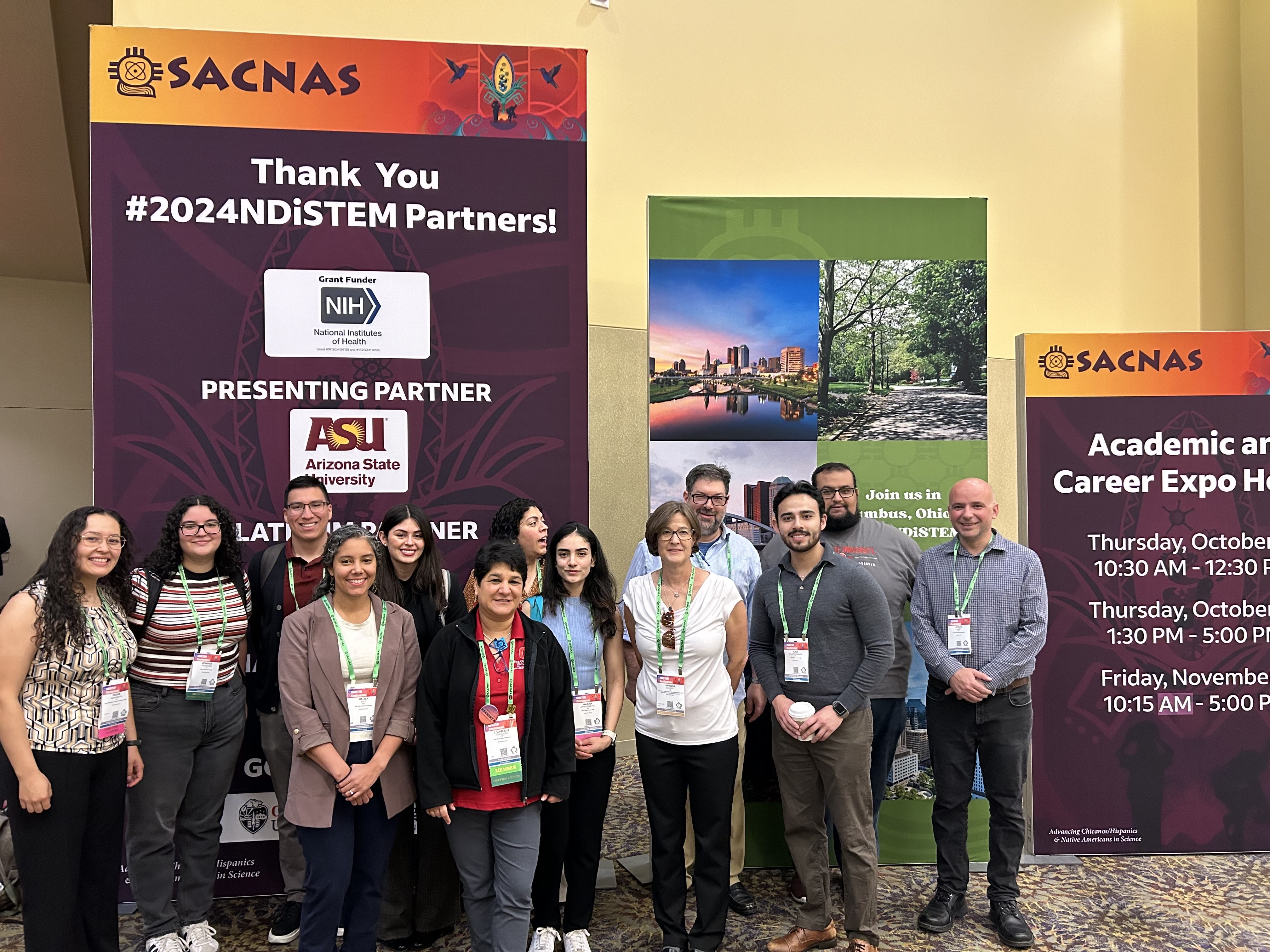 A group of students standing in front of the conference entrance