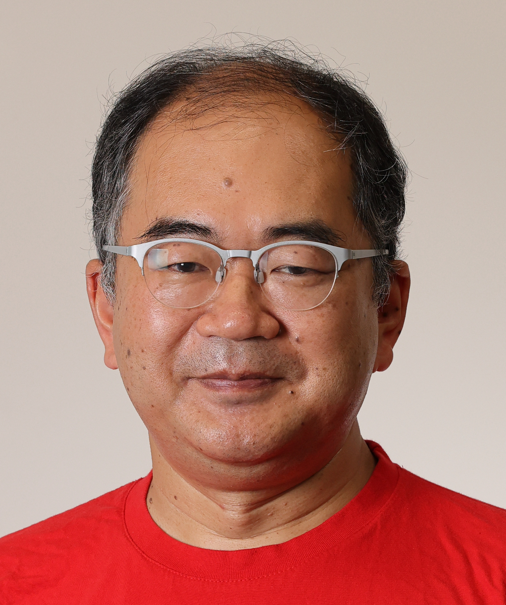 Professor Masaki Oshikawa in front of a white wall