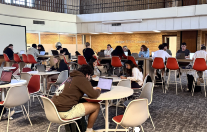 Students sitting at desks in groups and studying