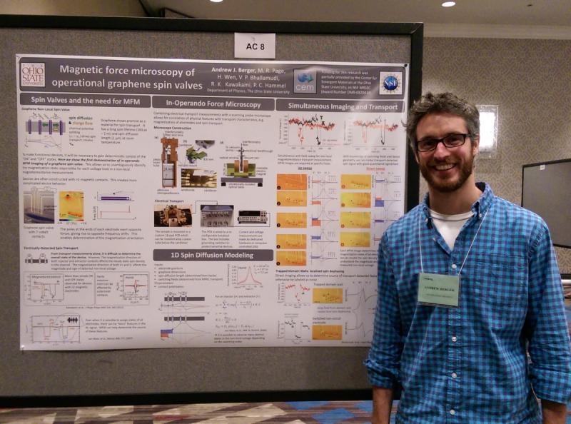 Researcher smiling and standing in front of research poster