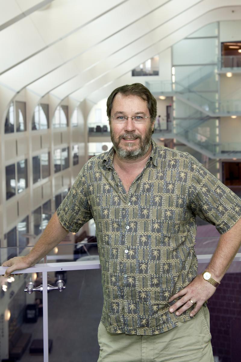 Jim Beatty smiling and leaning on handrail with PRB Atrium in the background