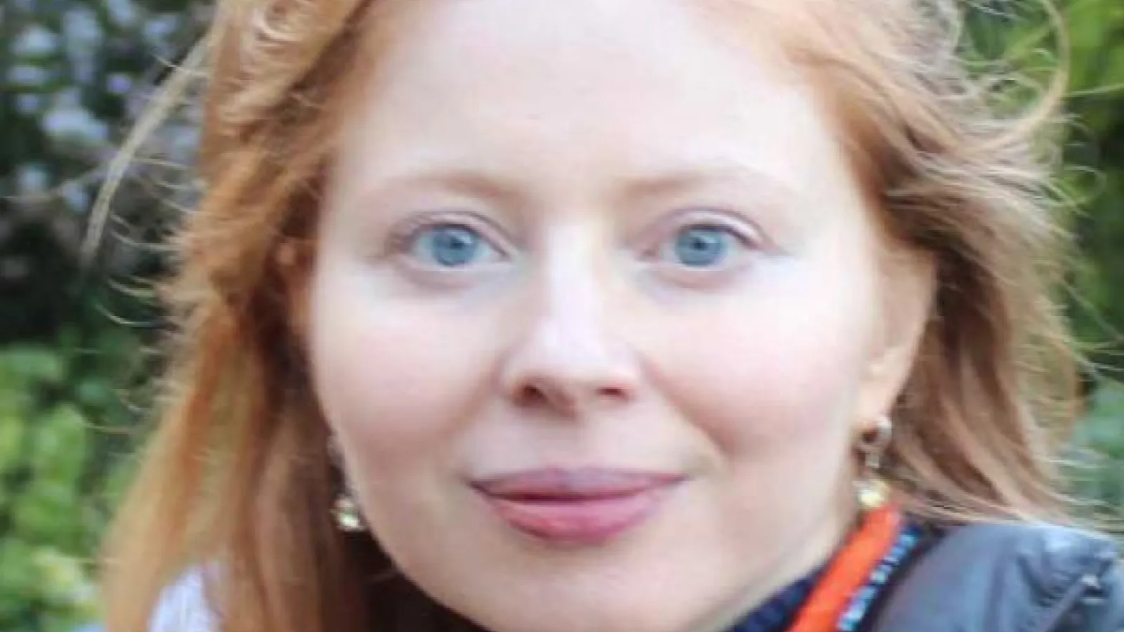 Professor Landsman close up with trees behind her