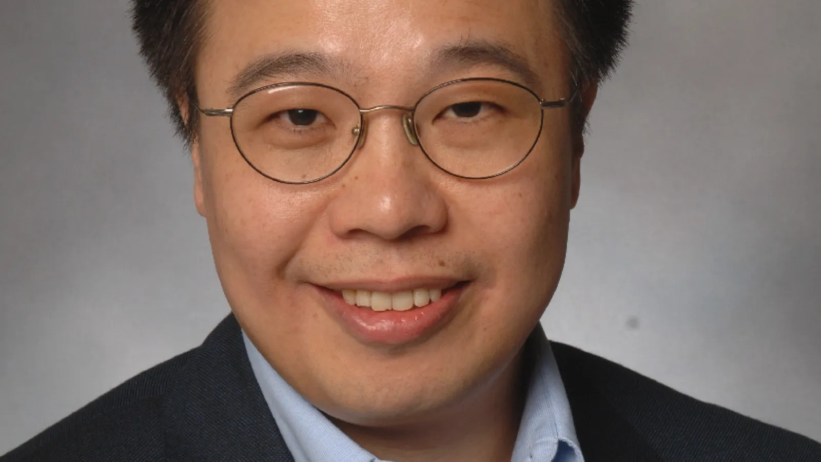Professional photo of Qimiao Si in front of grey background