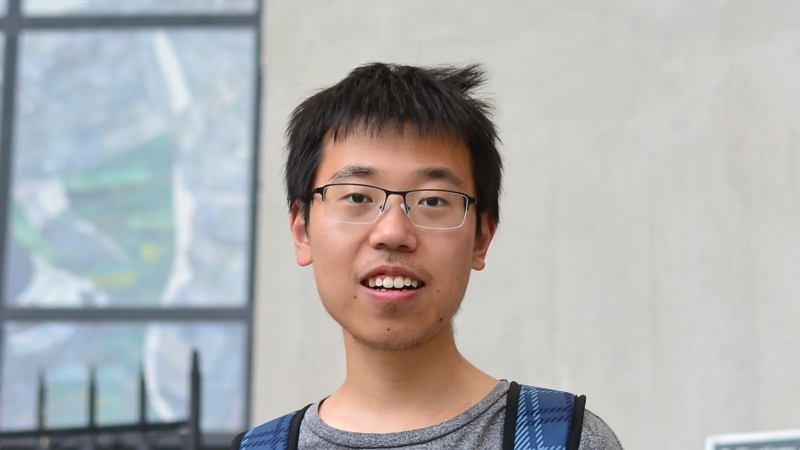 Bowen Shi with beige wall and window in the background