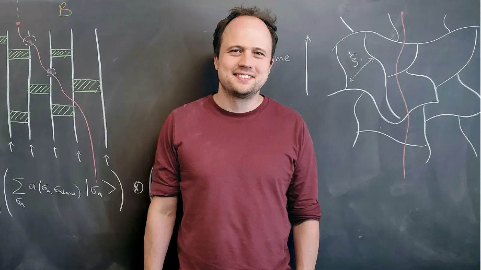 Brian Skinner in front of a chalkboard