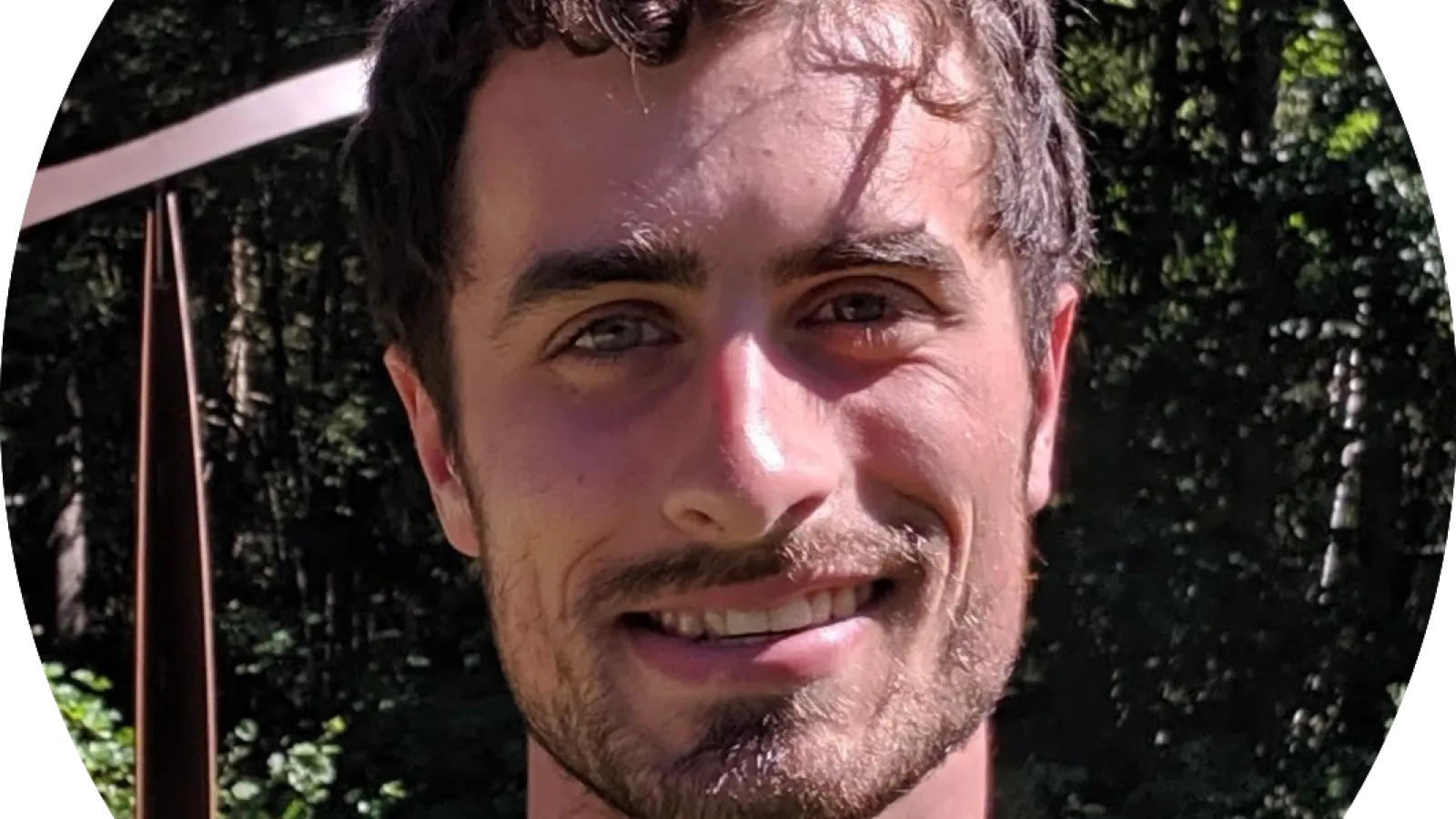 Headshot of Ethan Lake, trees in background