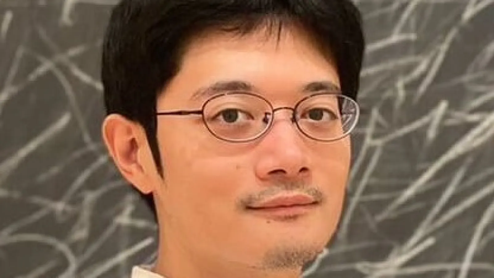 Takashi with blackboard in the background