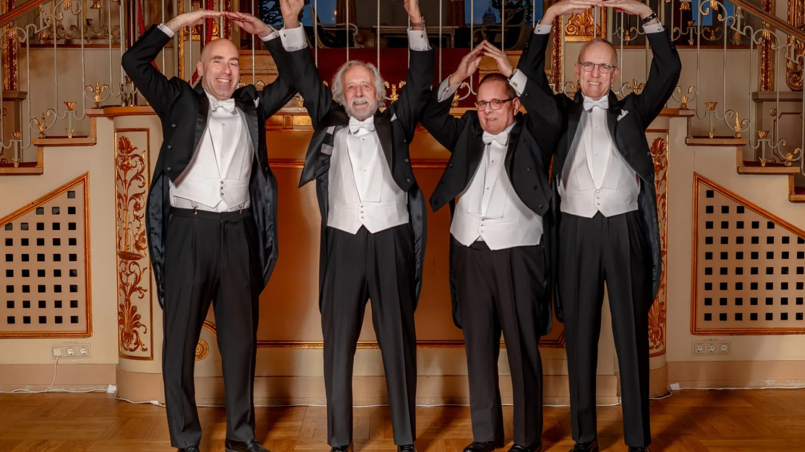 From left to right, Michael Poirer, Pierre Agostini, Lou DiMauro, and Dean Horn making the "O-H-I-O" signs with their arms, at Nobel Ceremony in Sweden.