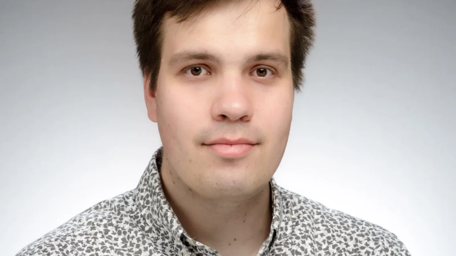 Headshot of Petr Stepanov with grey background