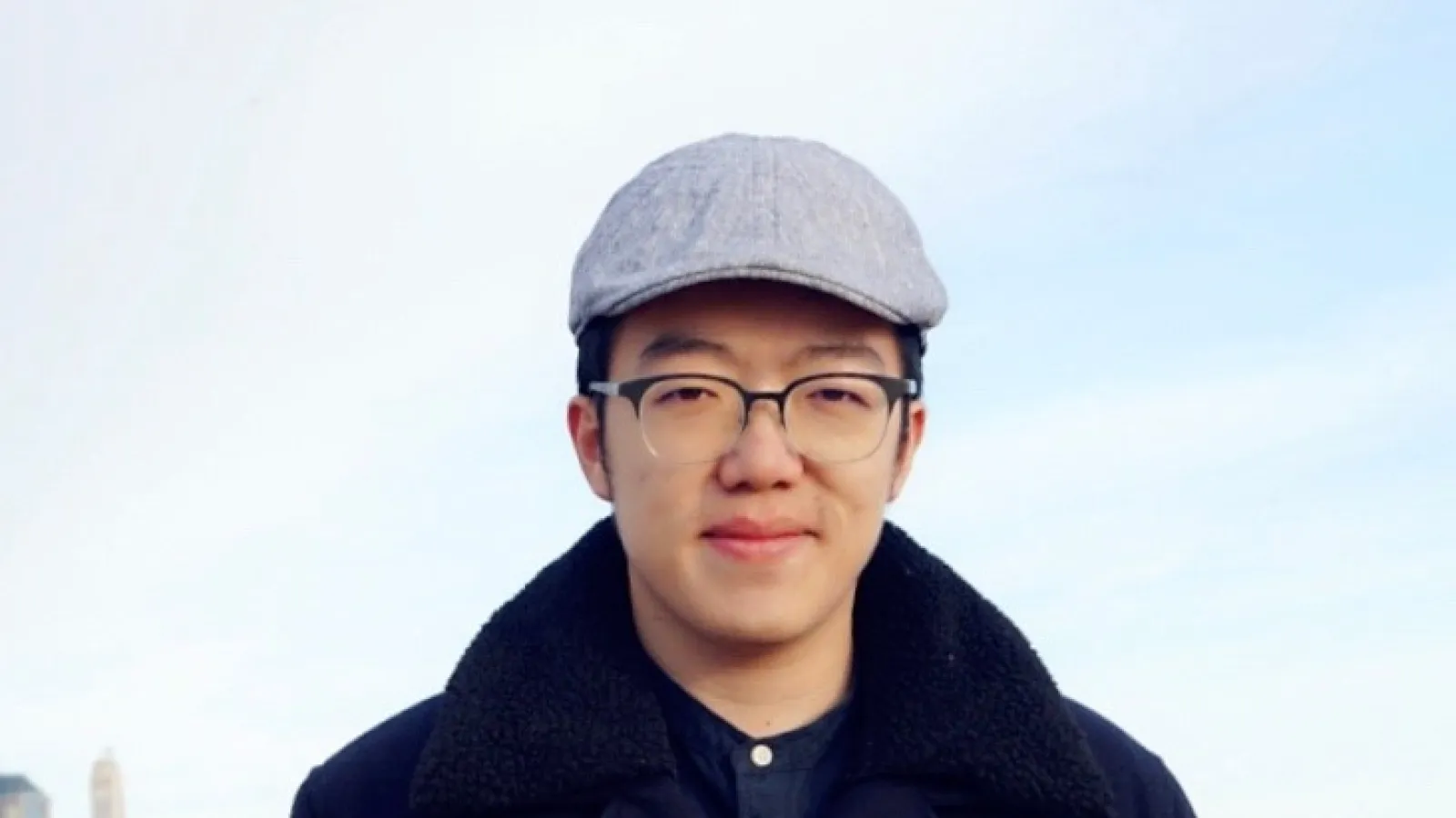 Shaowen Chen with city skyline in the background