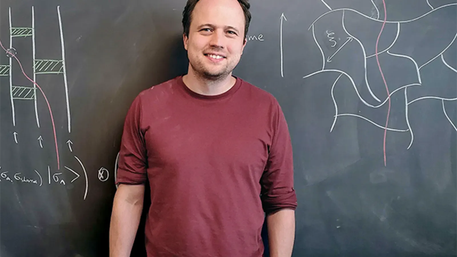 Brian Skinner in front of a chalkboard