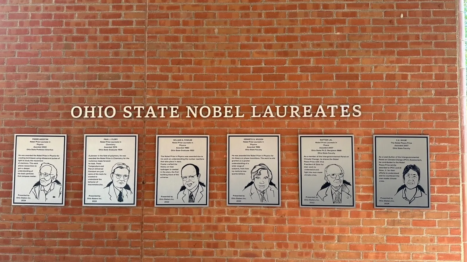 Row of silver Nobel Winner plaques on wall of 18th street library