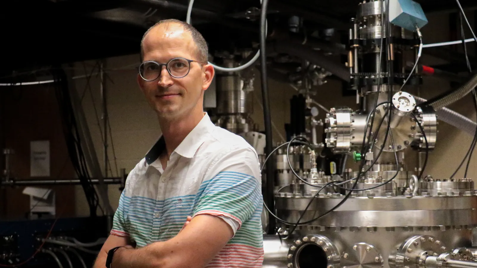 Michael Chini standing with arms crossed in the lab