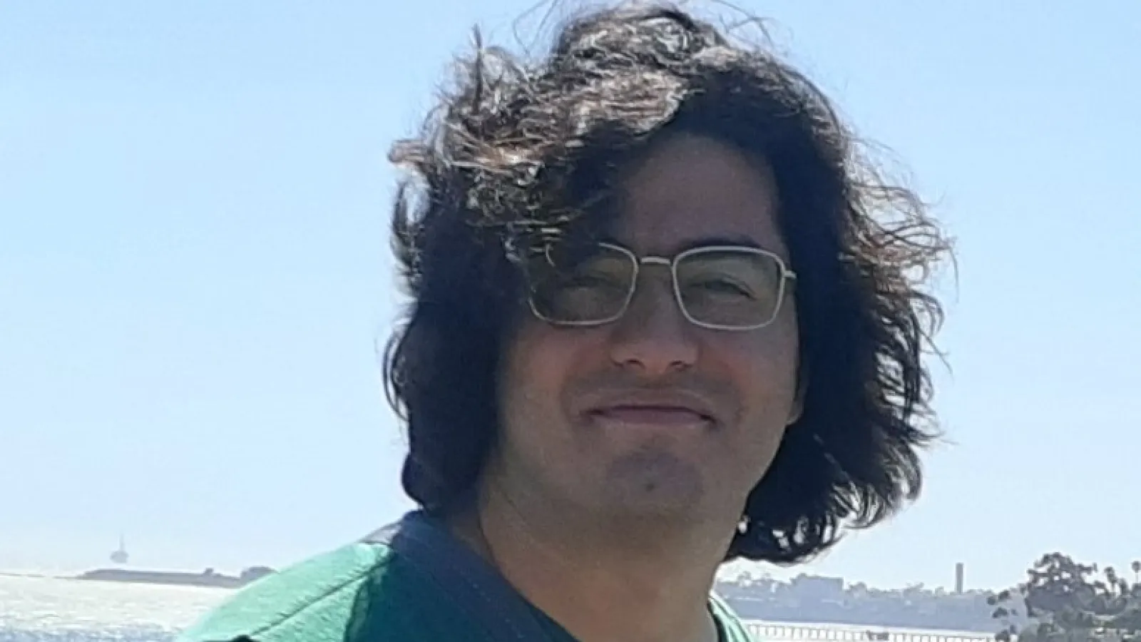 Alireza smiling with bright blue sky in the background
