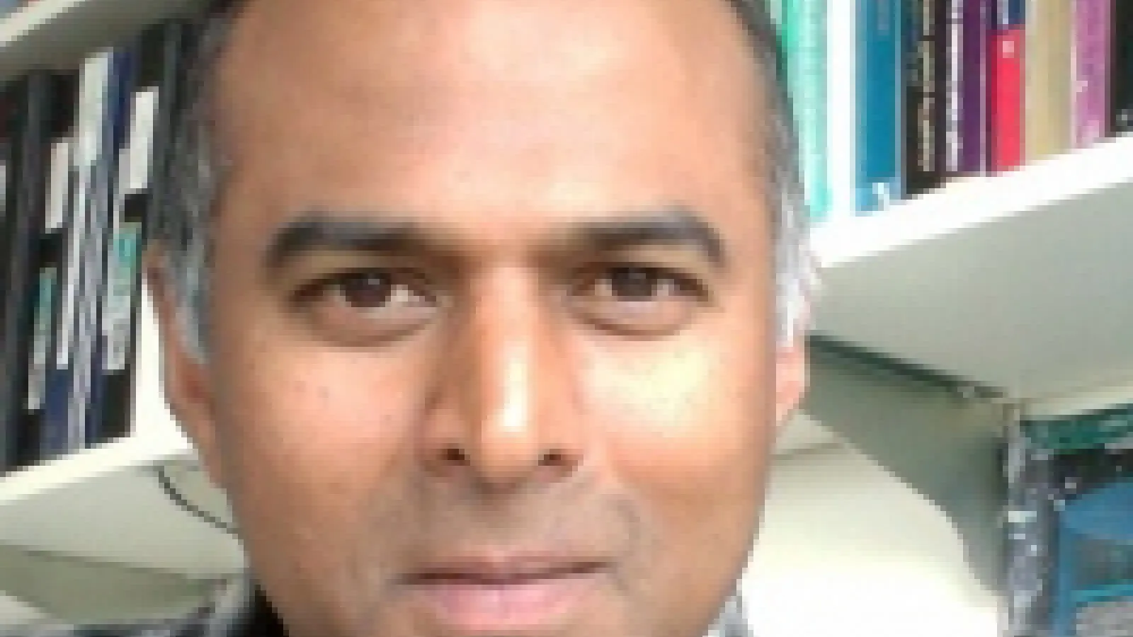Prof. Reddy in front of a bookcase