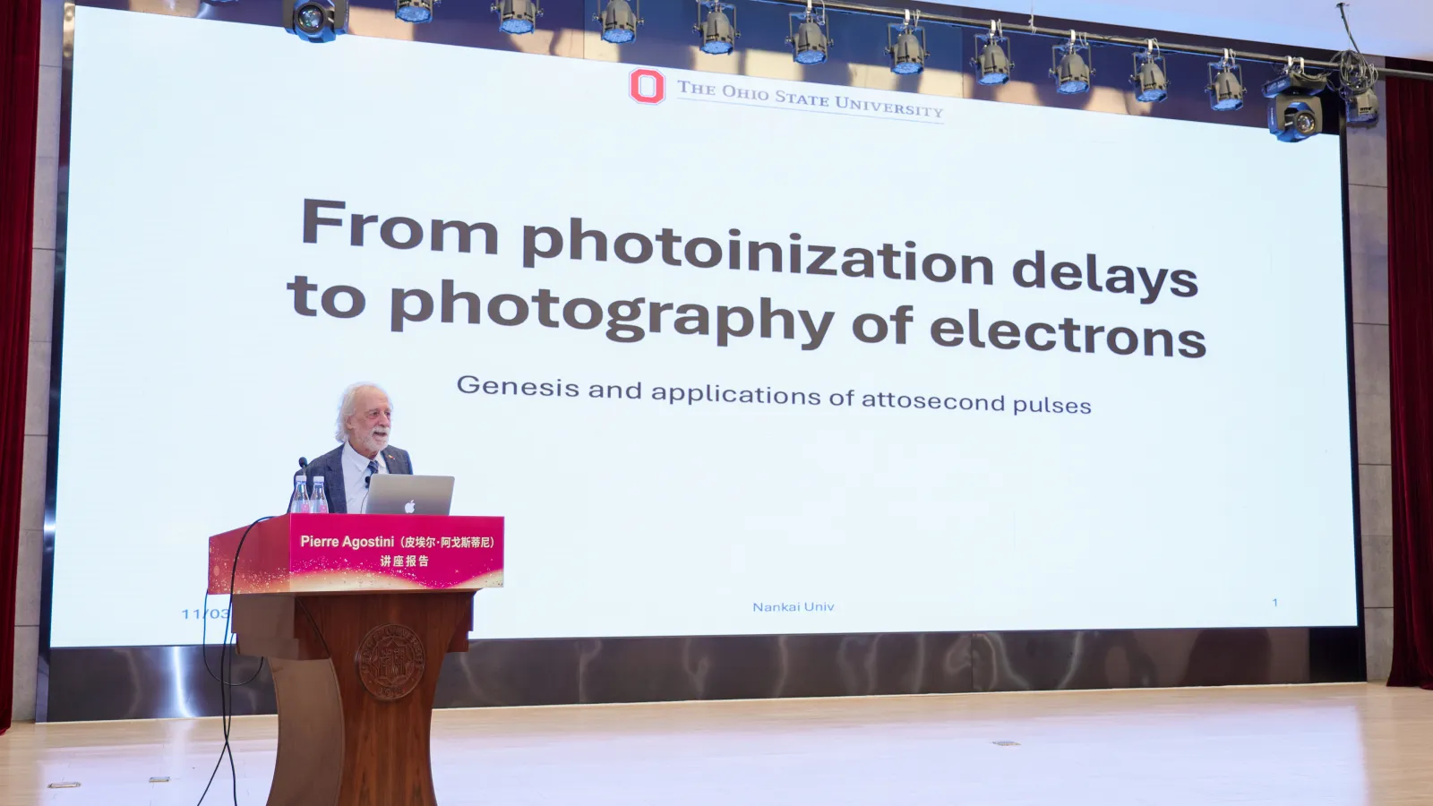 Pierre Agostini at a podium speaking about attosecond pulses