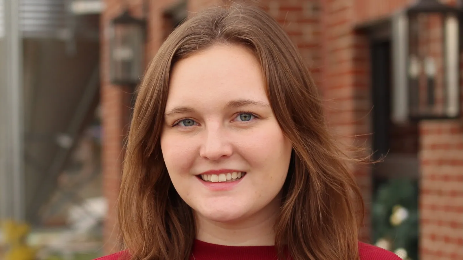 Maura Kelley smiling in front of a brick building