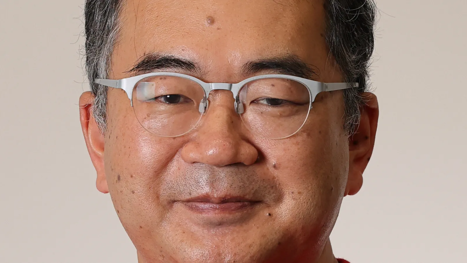 Professor Masaki Oshikawa in front of a white wall