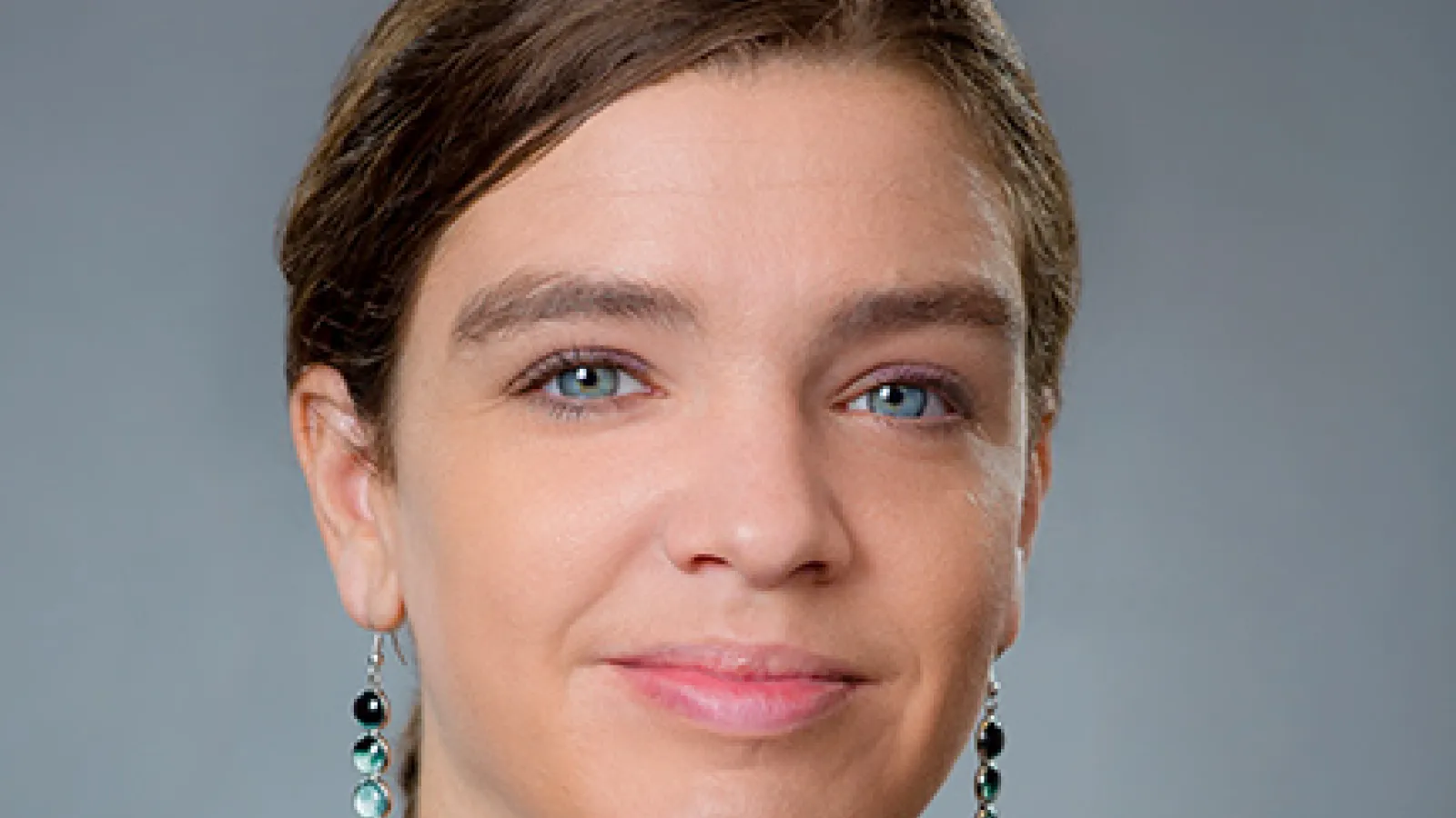 Therese Jones smiling with a grey background