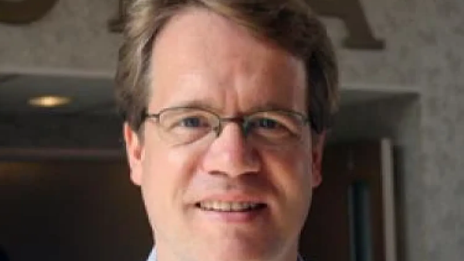 Andreas Becker smiling in front of a doorway