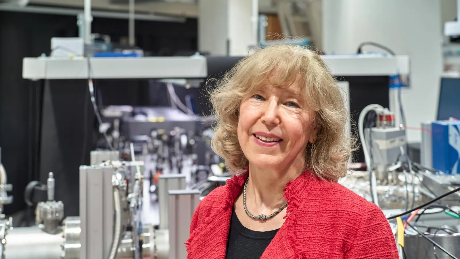 Nora Berrah smiling in a lab.