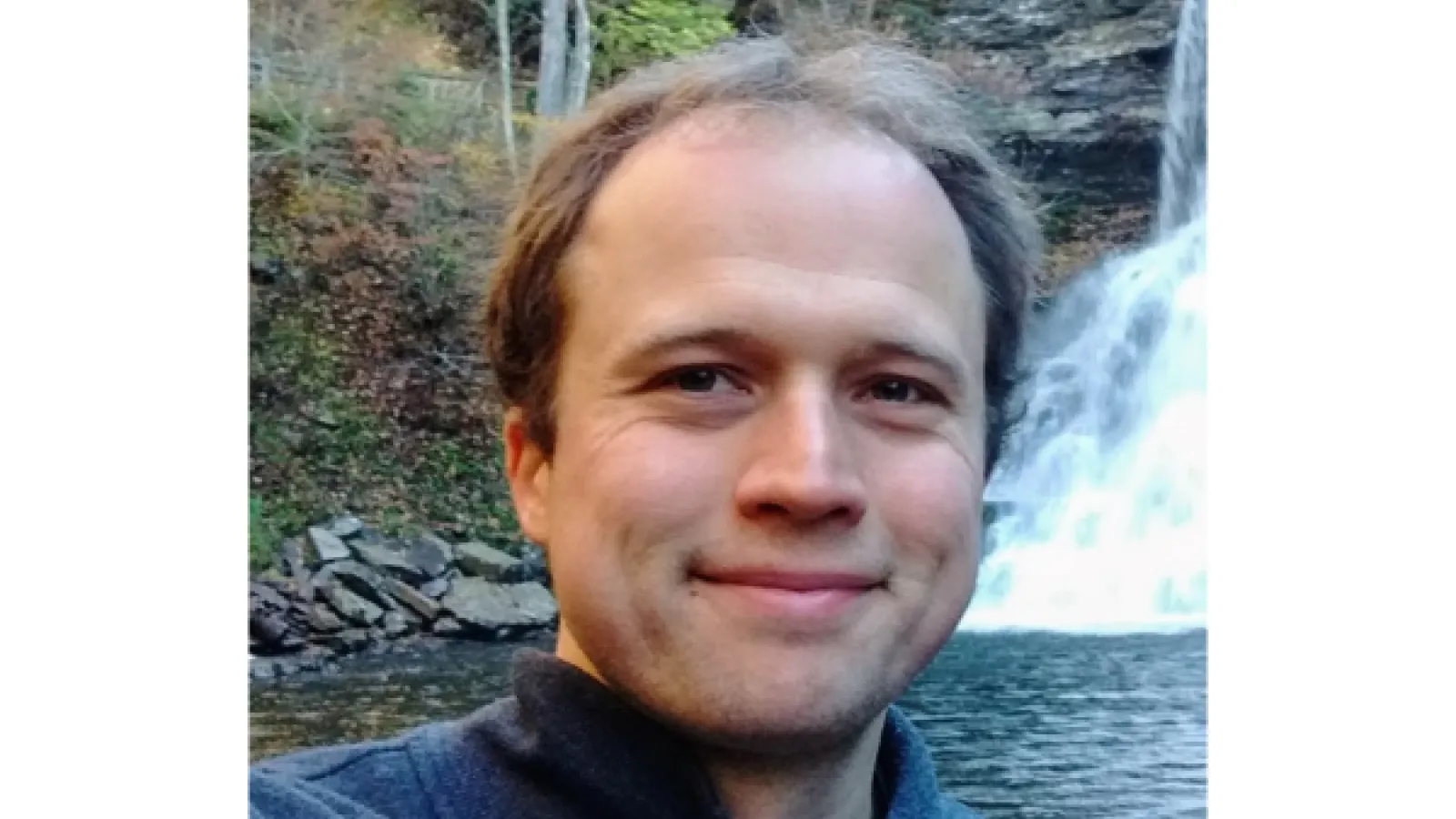 Headshot of Brian Skinner in front of a waterfall.