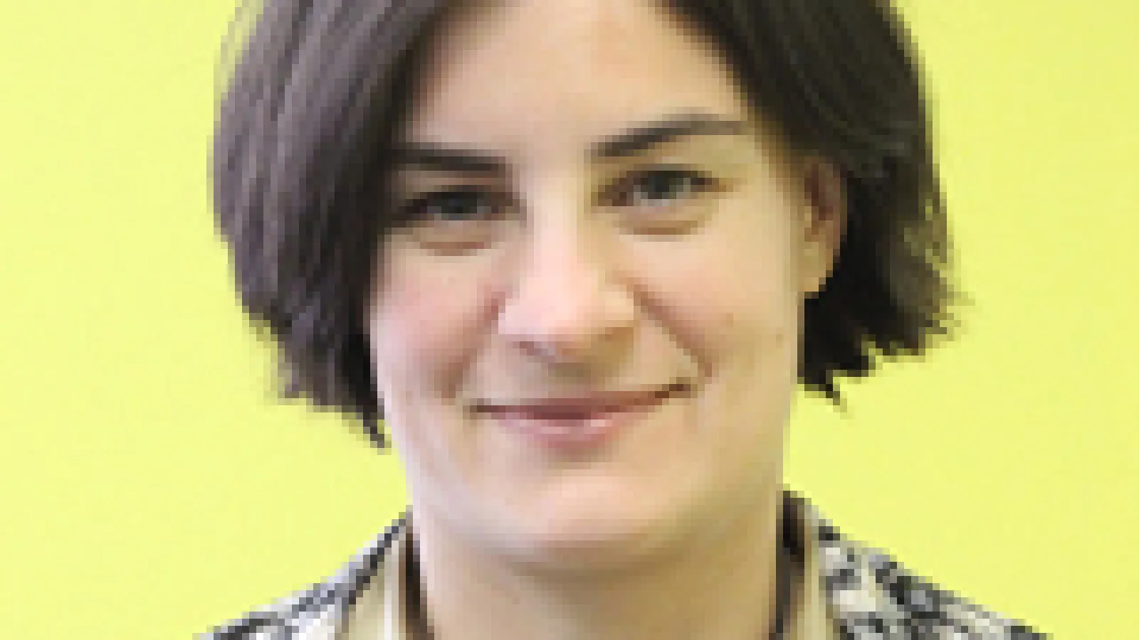A headshot of Amy Connolly with a yellow background.