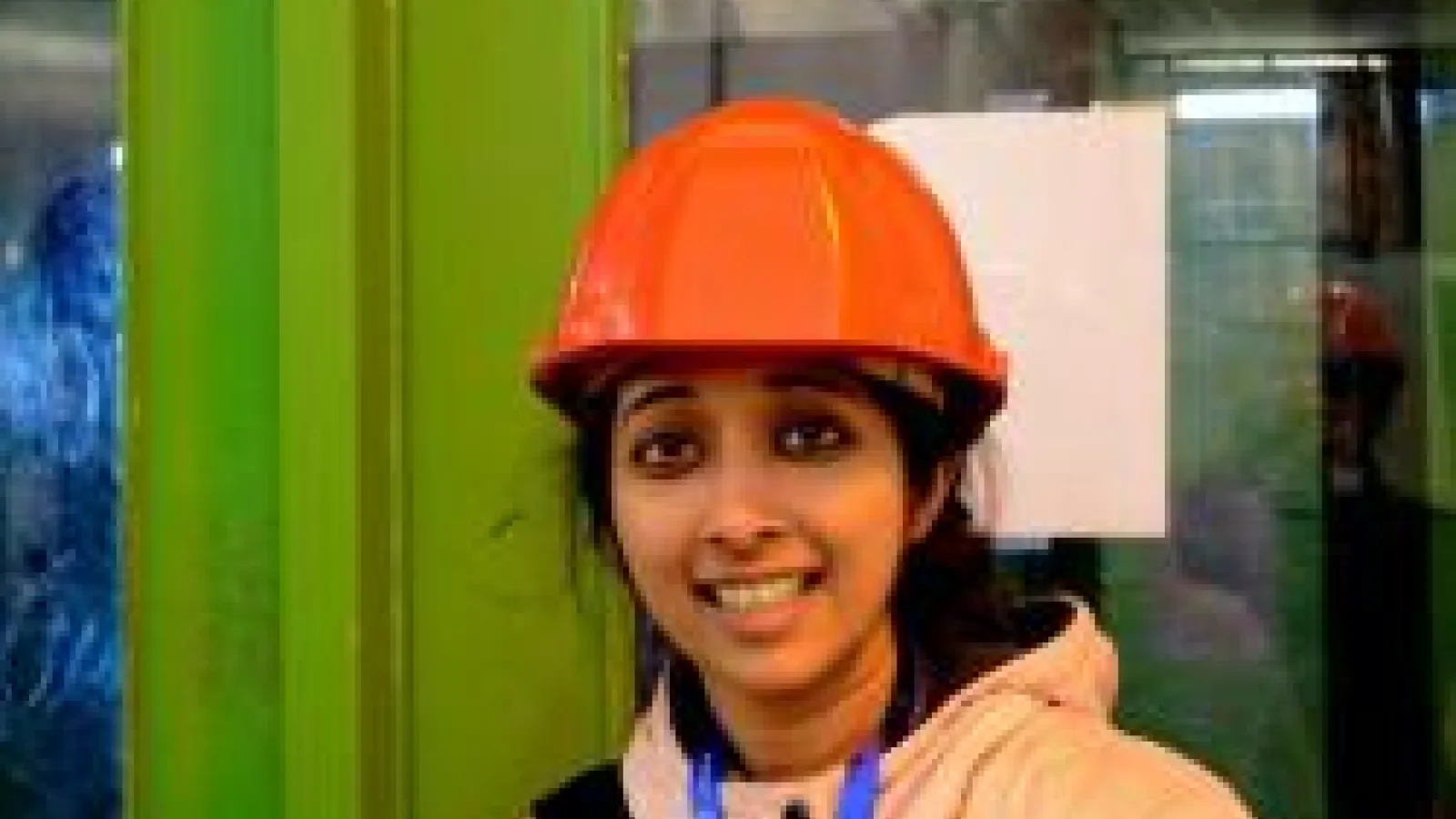 Archana Anandakrishnan smiling in orange hard hat