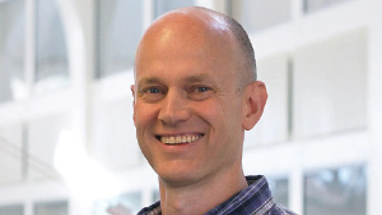John Beacom smiling and standing in PRB Atrium