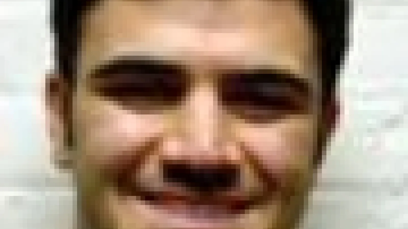 Blurry headshot of Comert Kural with white wall behind him