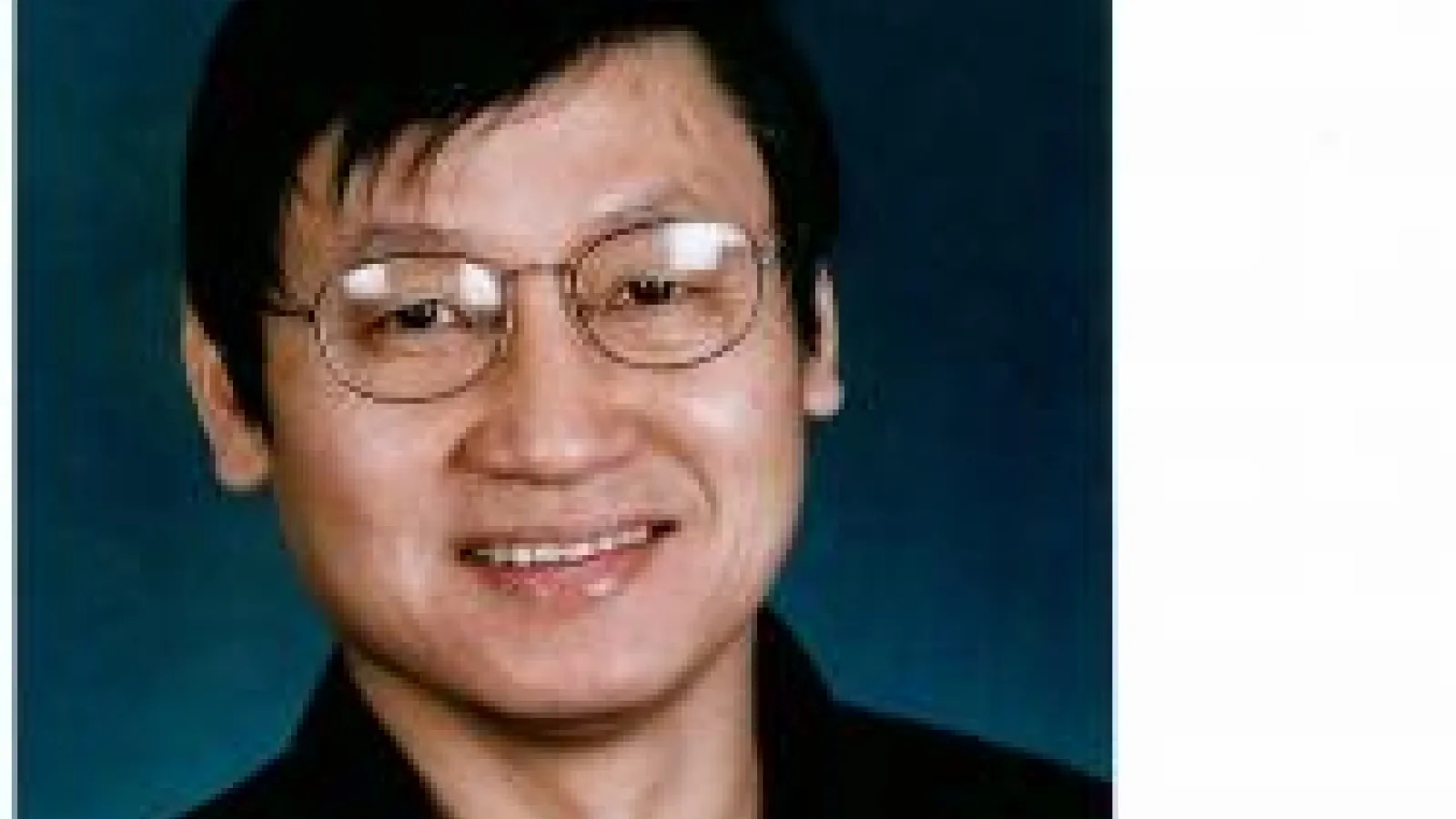 Jason Ho smiling with blue background
