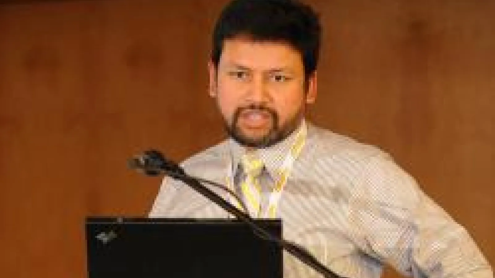 Dr. Enam Chowdhury speaking at podium