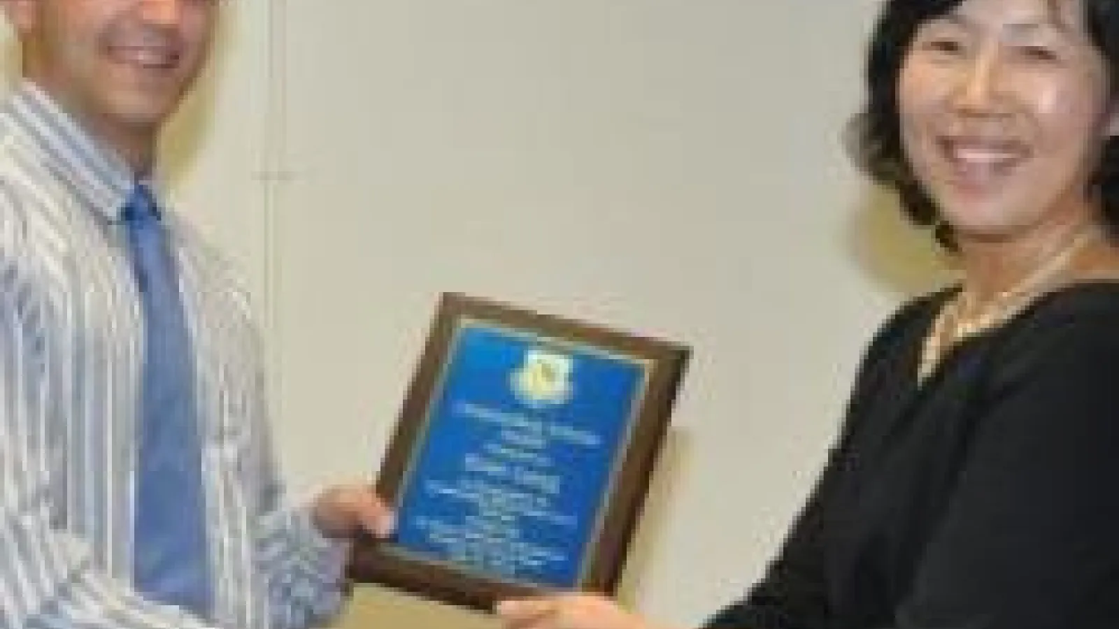 Evan Lang smiling and holding his award