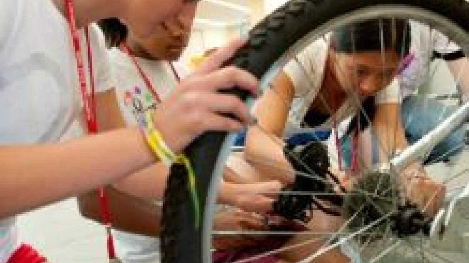 Students working on fixing a bicycle tire gear