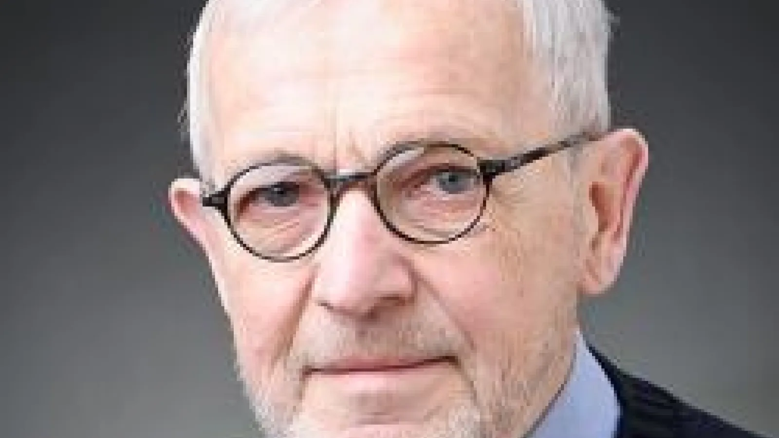 Francis Halzen with plain black and grey background