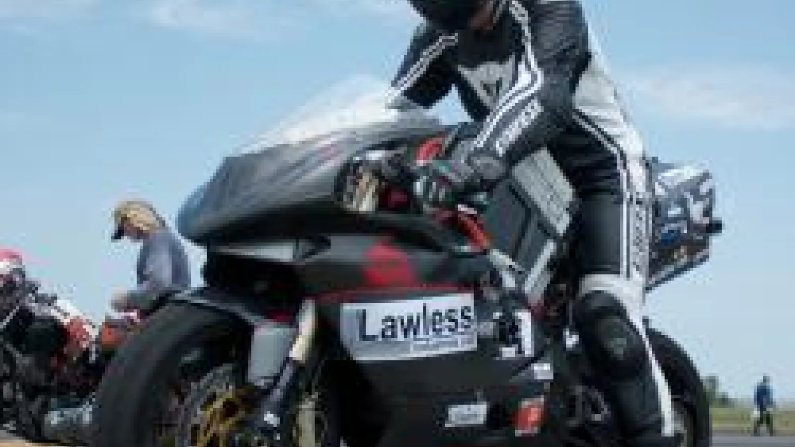 Jenn on electric motorcycle with blue sky behind her
