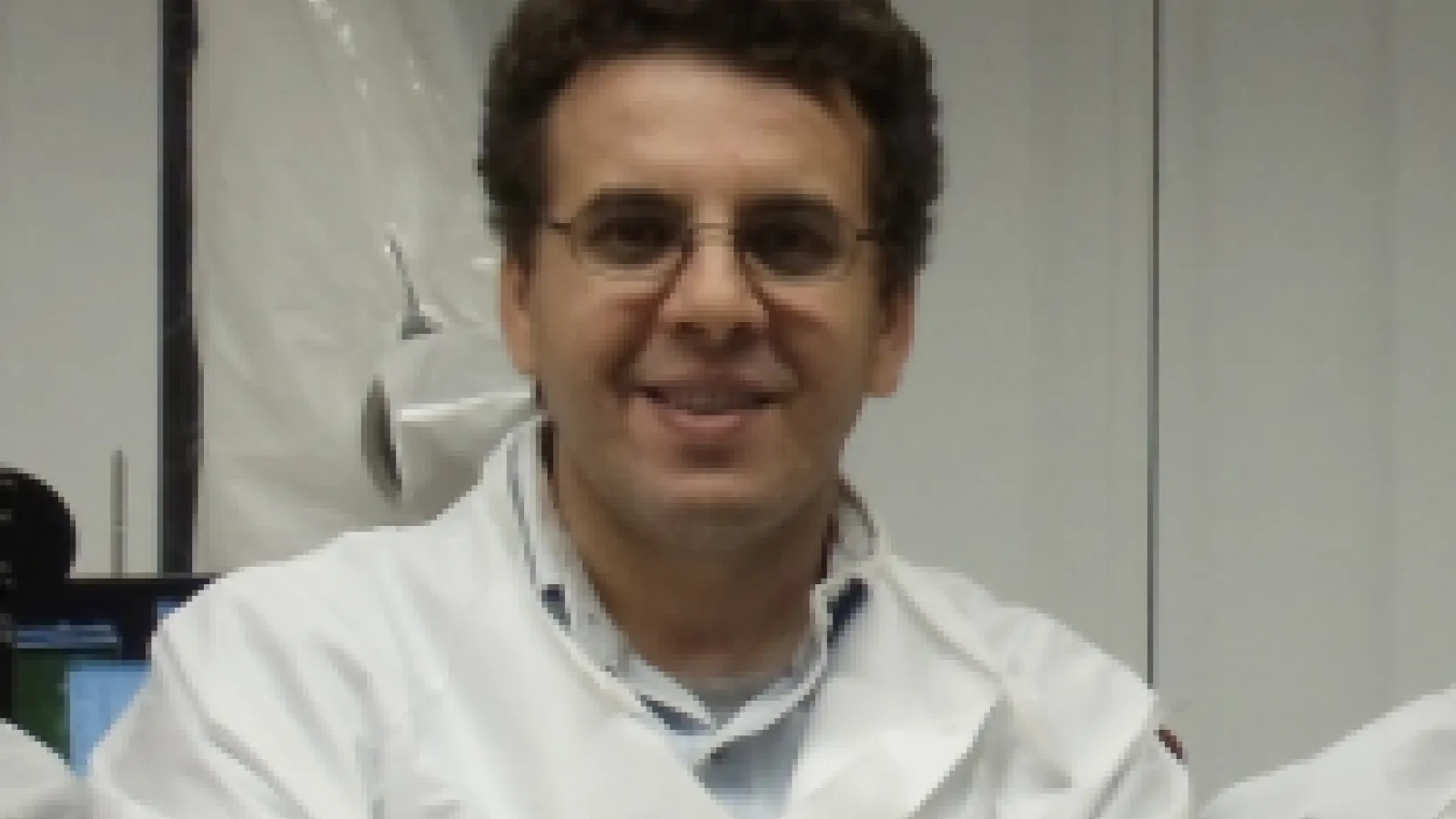 A close-up of Dr. Kramer Akli in a white lab coat.