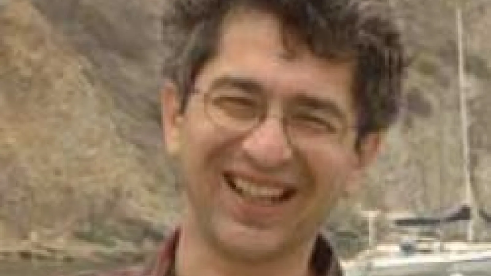 Shirman smiling with hill and lake in the background