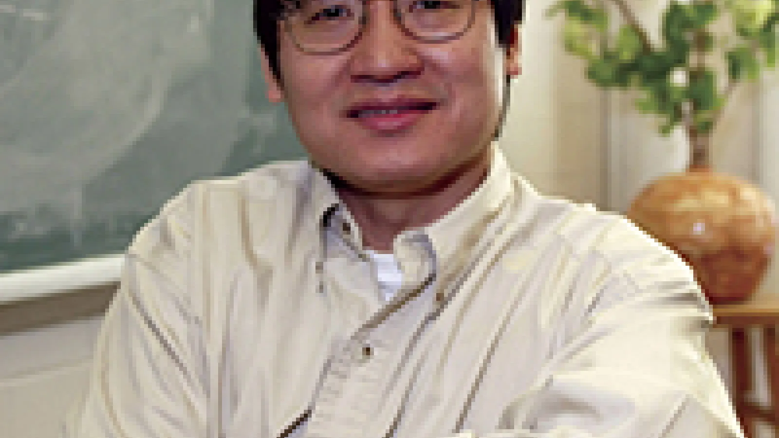 Jason Ho smiling and sitting in his office