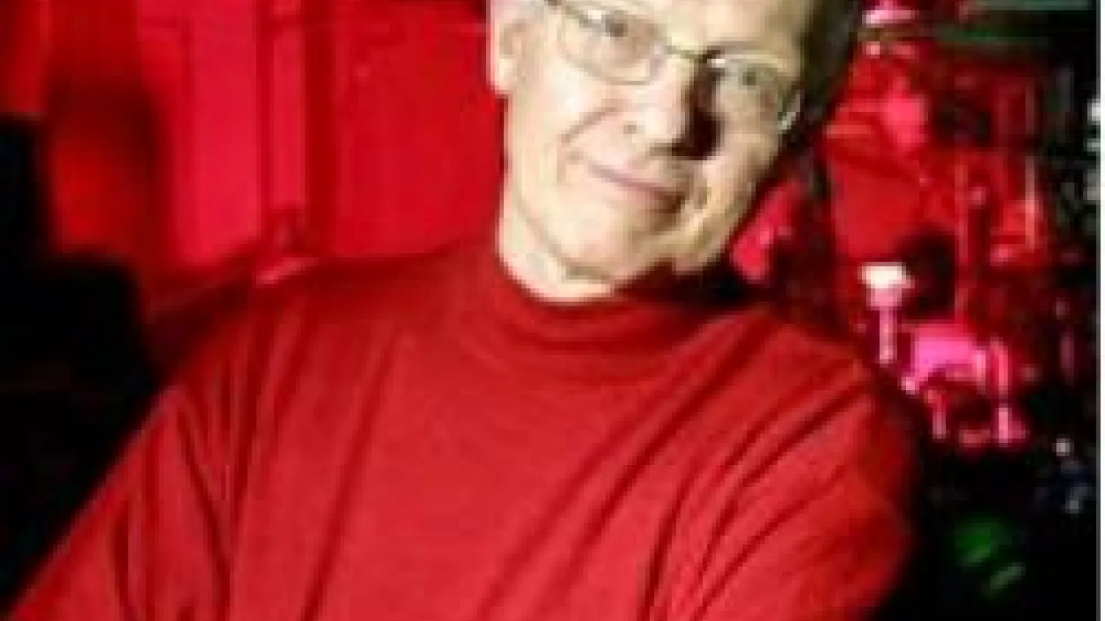 A headshot of Paul Corkum with a red laboratory background.